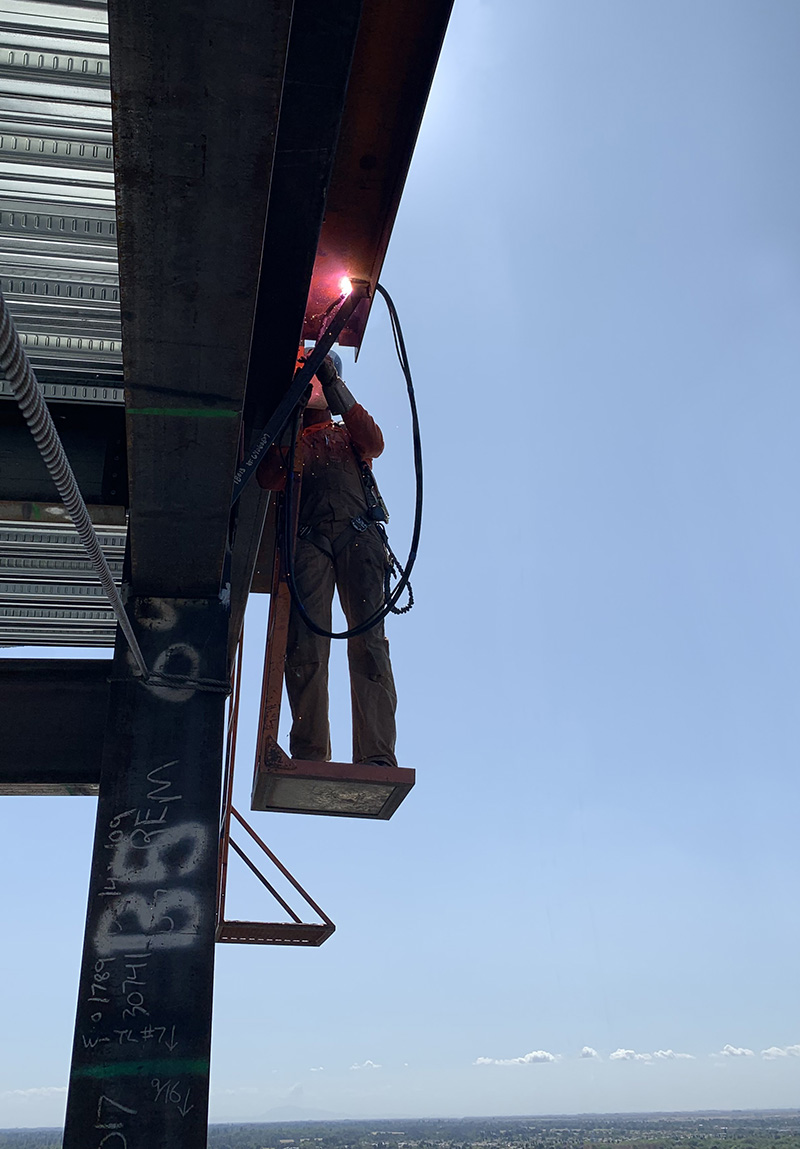 man welding a trailer hitch